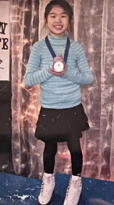 Amy at a skating competition with a medal