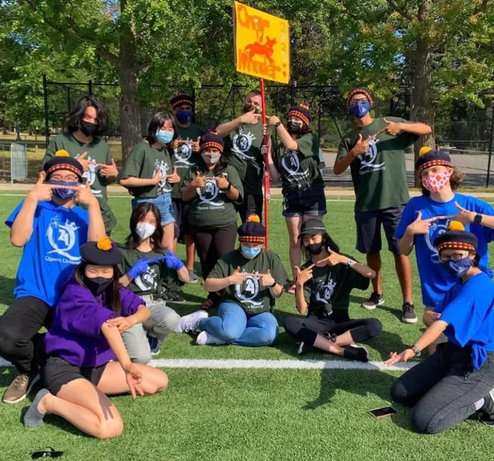 A group of students posing on a field at a Queen’s event